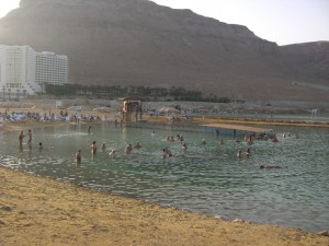 Turisti fanno il bagno nel tepore della sera, godendosi la leggerezza dell’acqua del mar Morto, che impedisce di fatto di affondare anche senza nuotare.